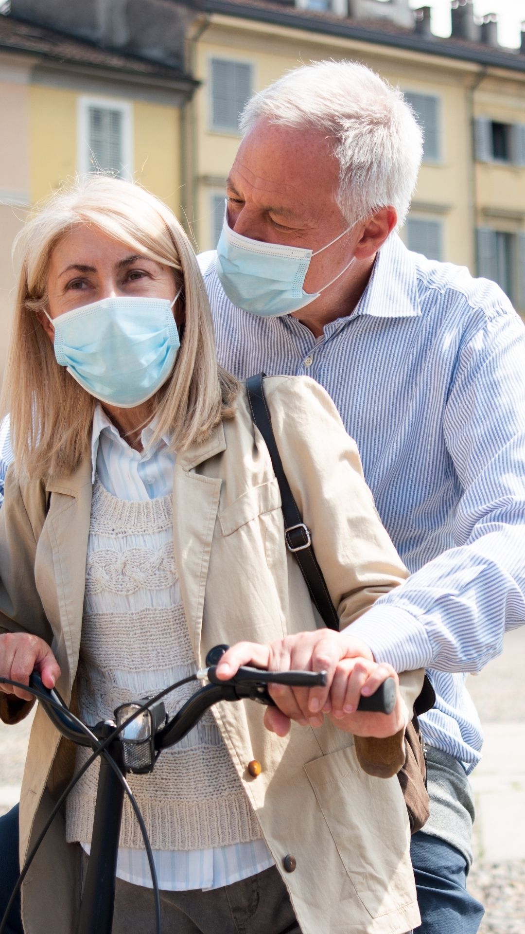 2 elderly couple with masks on an ebike